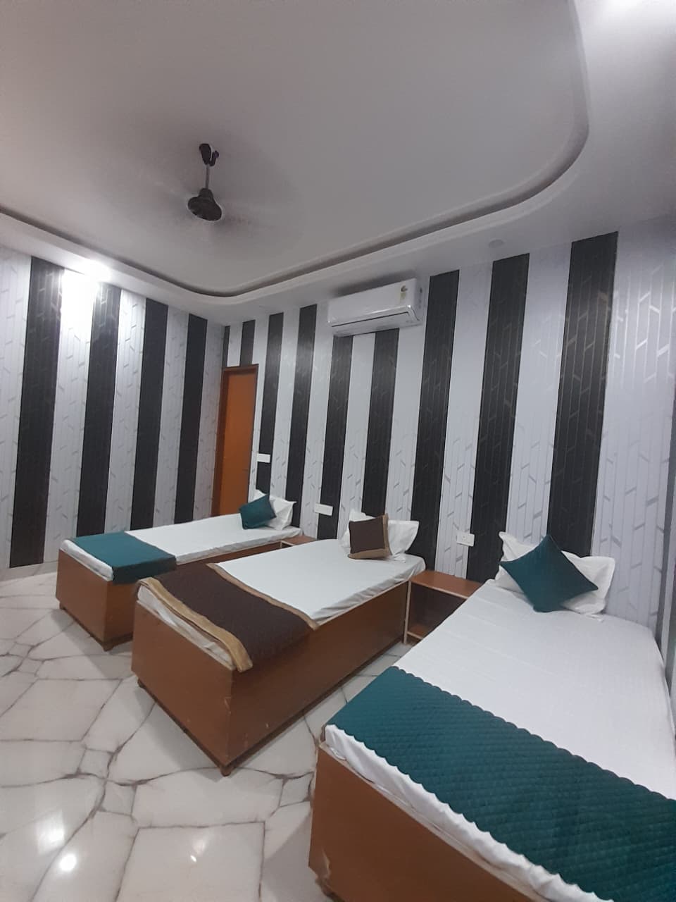 Triple-sharing room at Shree Shyam hostels with multiple comfortable beds